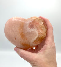 Load image into Gallery viewer, Hand holding pink amethyst heart
