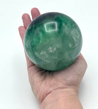 Load image into Gallery viewer, Fluorite Sphere in hand.
