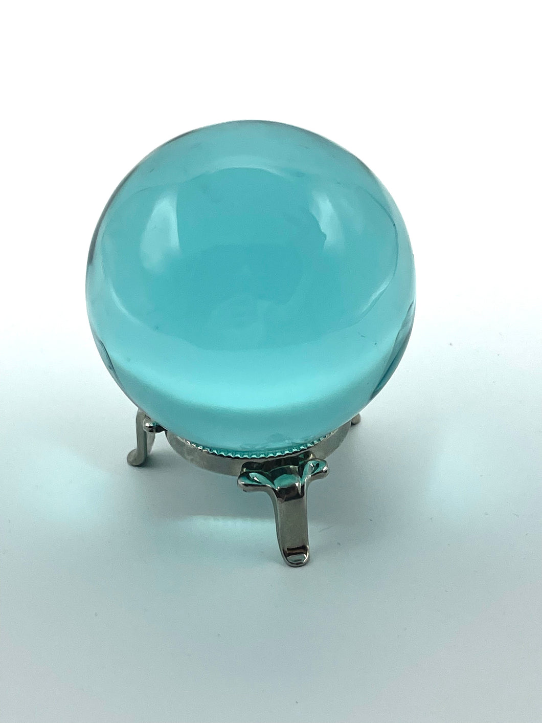 Aqua blue obsidian sphere on metal stand 