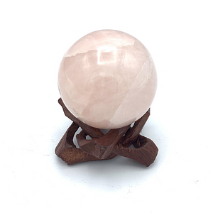 brown wooden stand with rose quartz sphere 